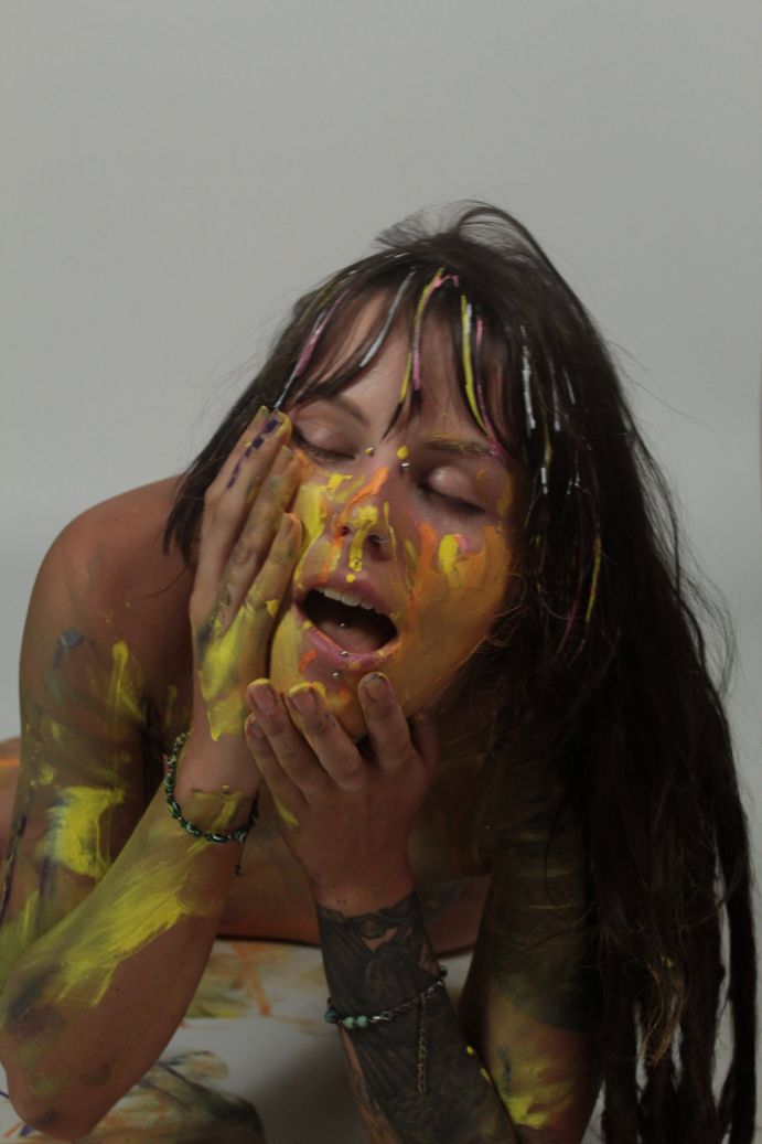 smeared colors of yellow and orange on model's face