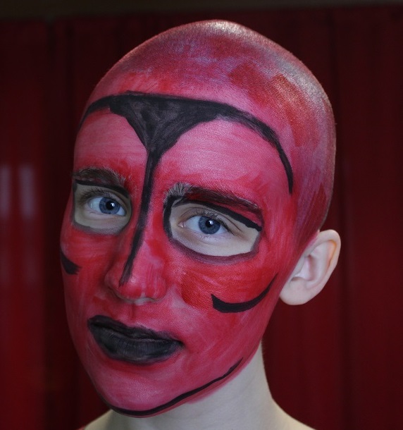 female face painted red with black outlines
