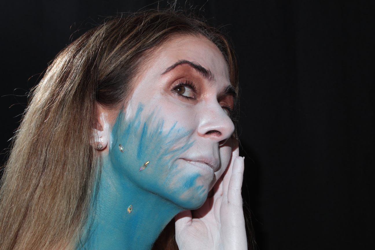 blue and white face paint with a few body jewels on the neck