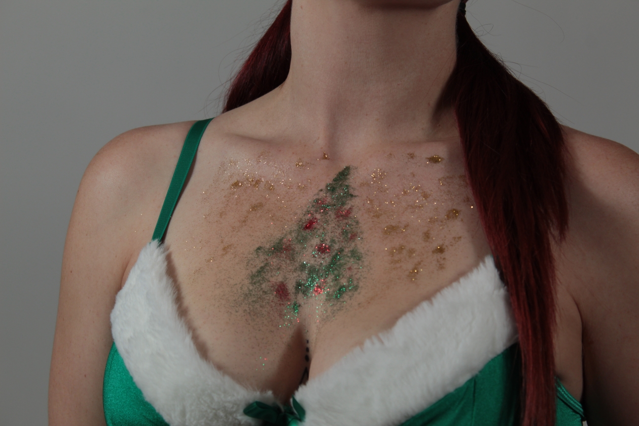 model with Christmas tree and ornaments painted in glitter on her chest