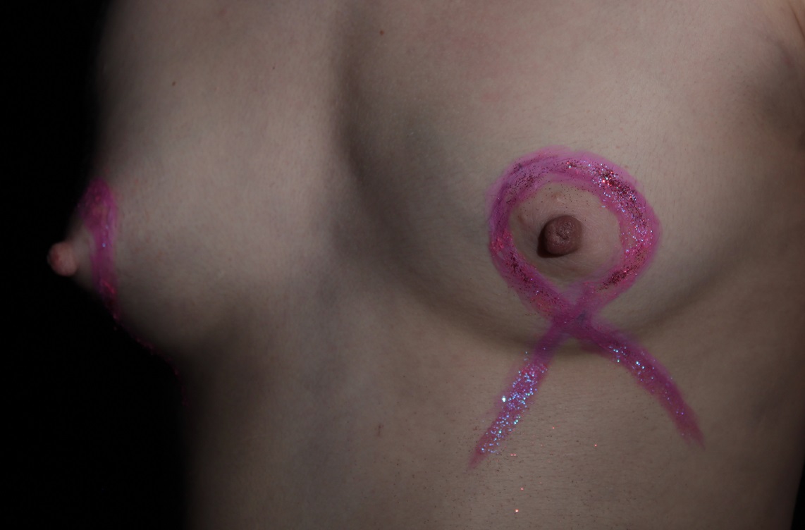 body painting of pink ribbon on woman's breast