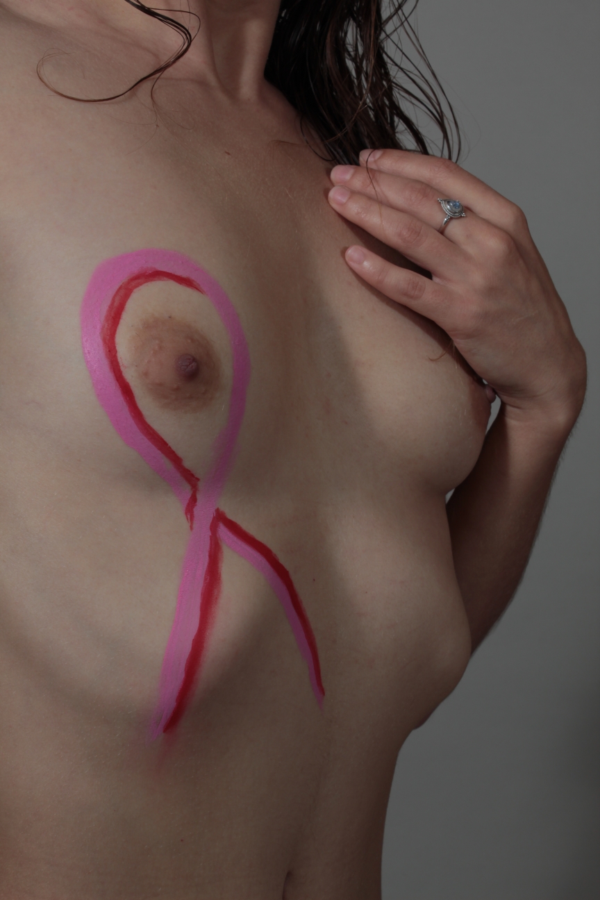 body painting of pink ribbon on woman's chest
