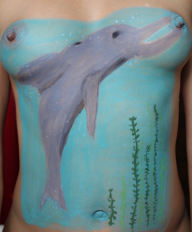 painting of dolphin on woman's torso
