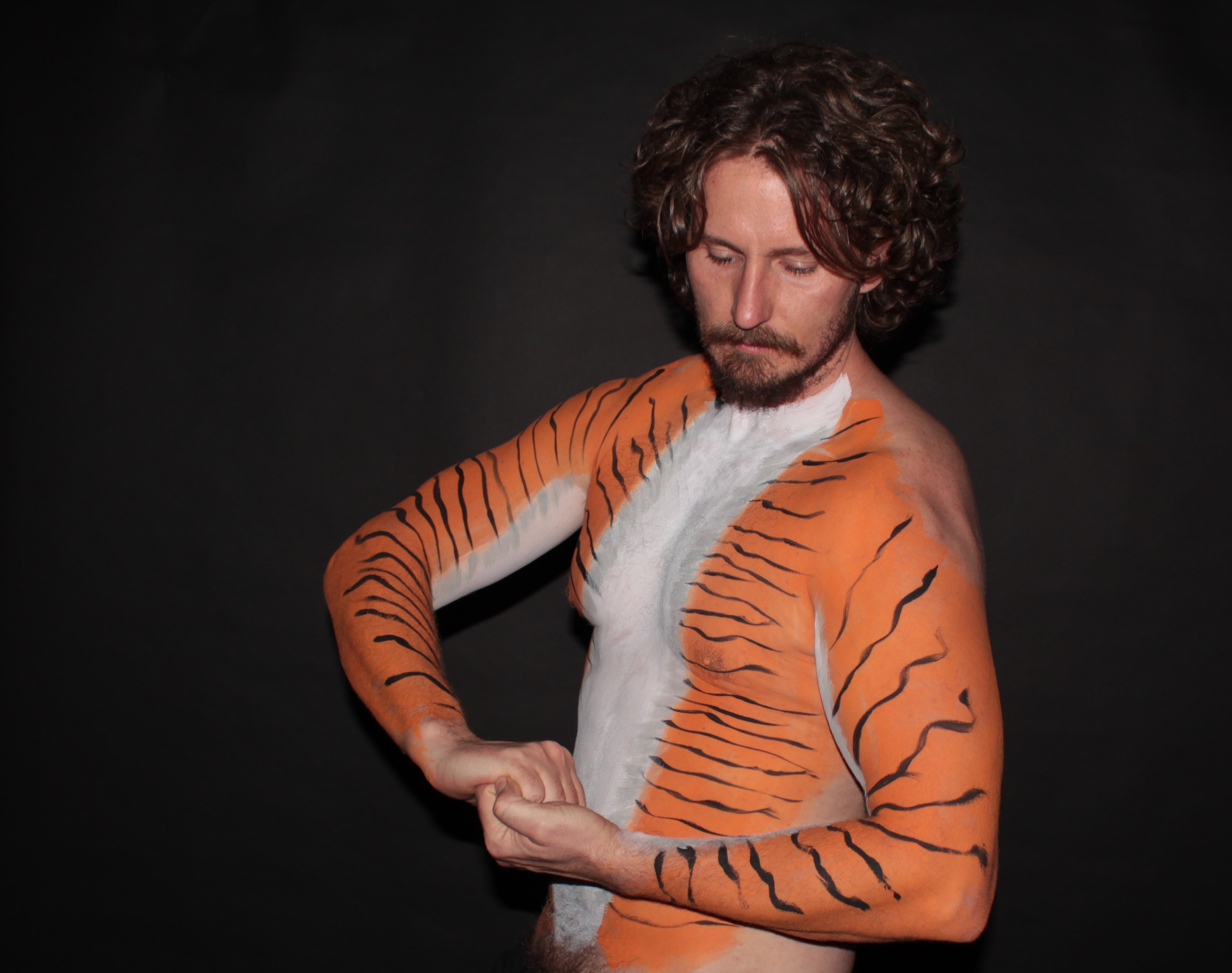 Male torso and arms body painted as a tiger.