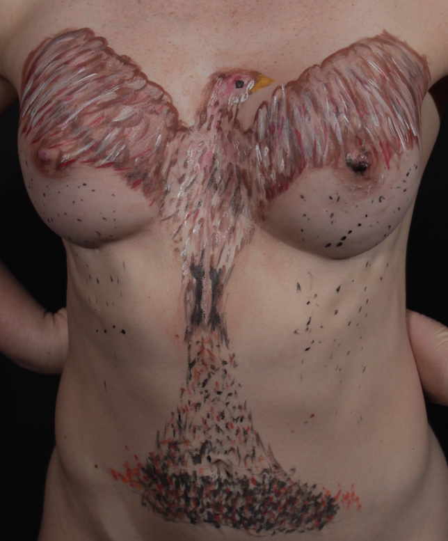 Phoenix rising from the ashes on woman's chest