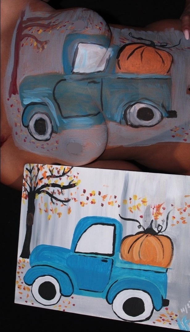 painting of truck with pumpkin in back on canvas next to copy on woman's torso