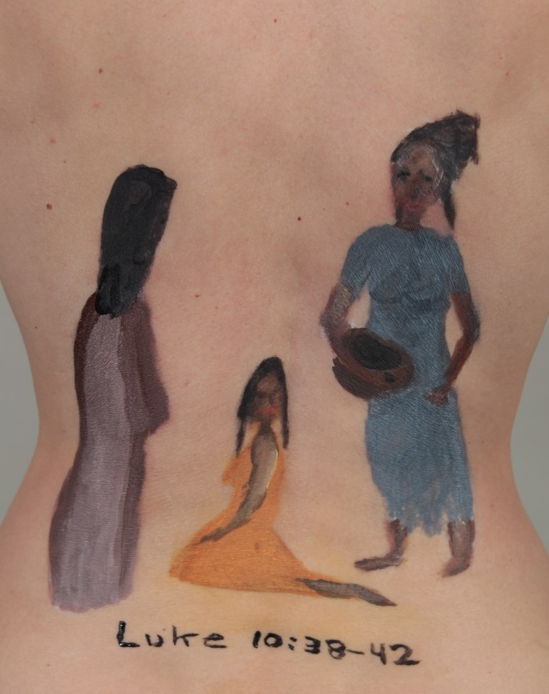 painting of Mary, Martha and Jesus on model's back