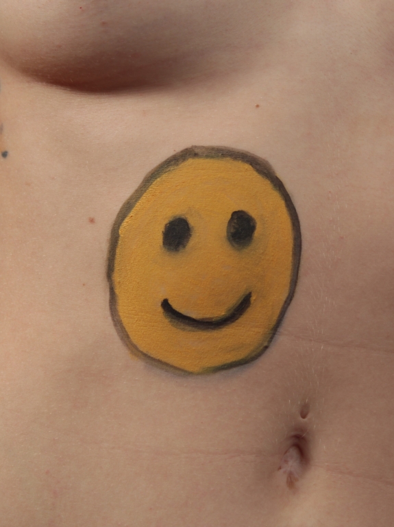 model with smiley face painted on her torso