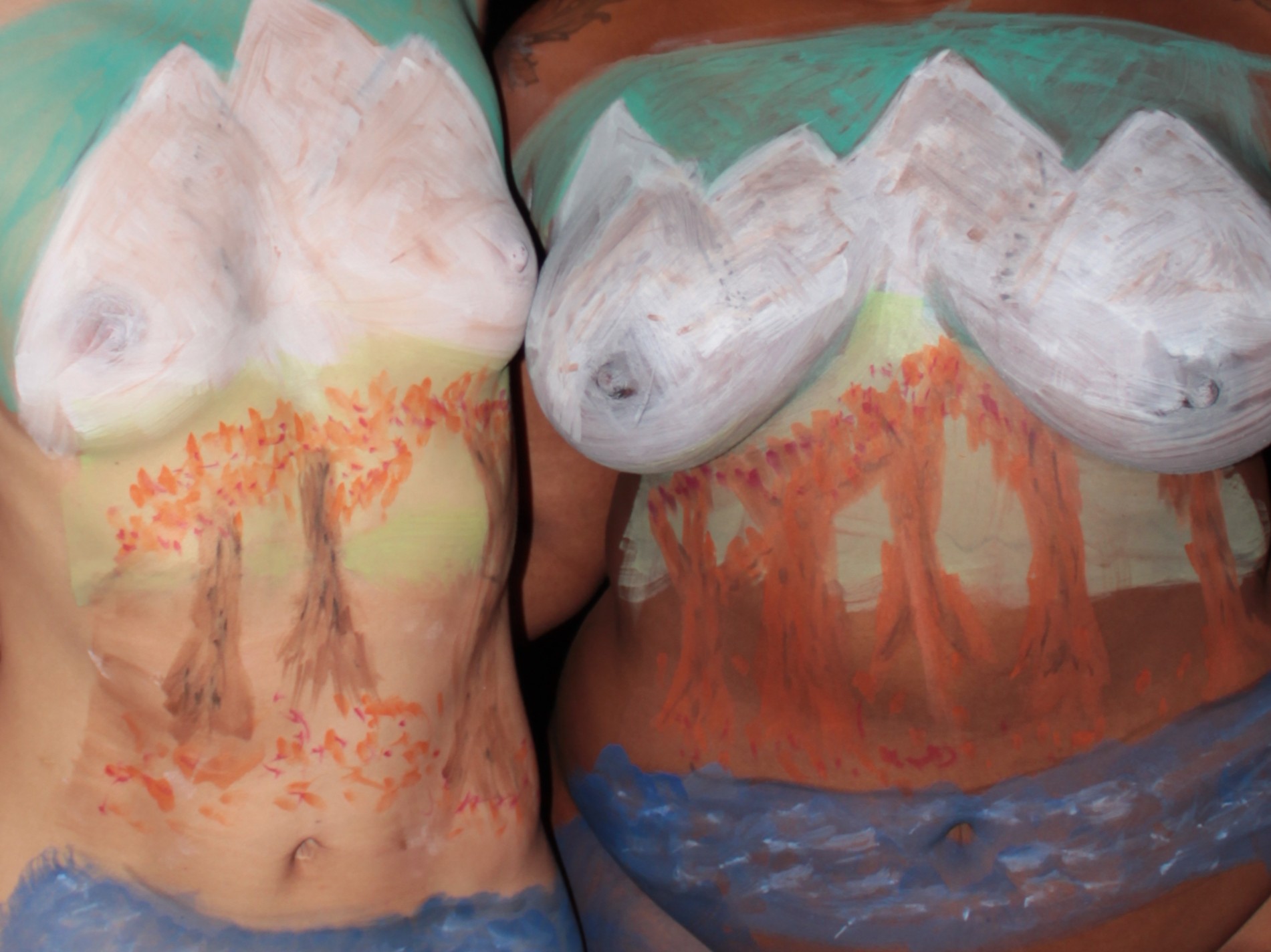 mural across the torsos of two women of snow covered mountains, trees and river