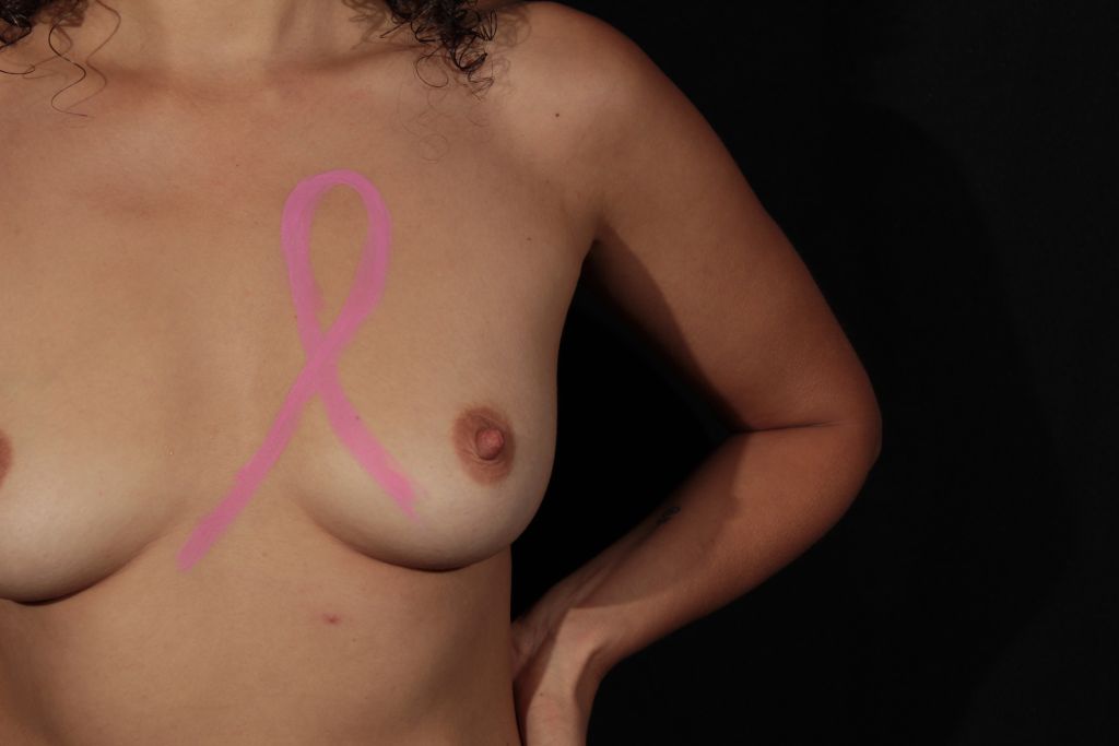 body painting of pink ribbon on woman's breast
